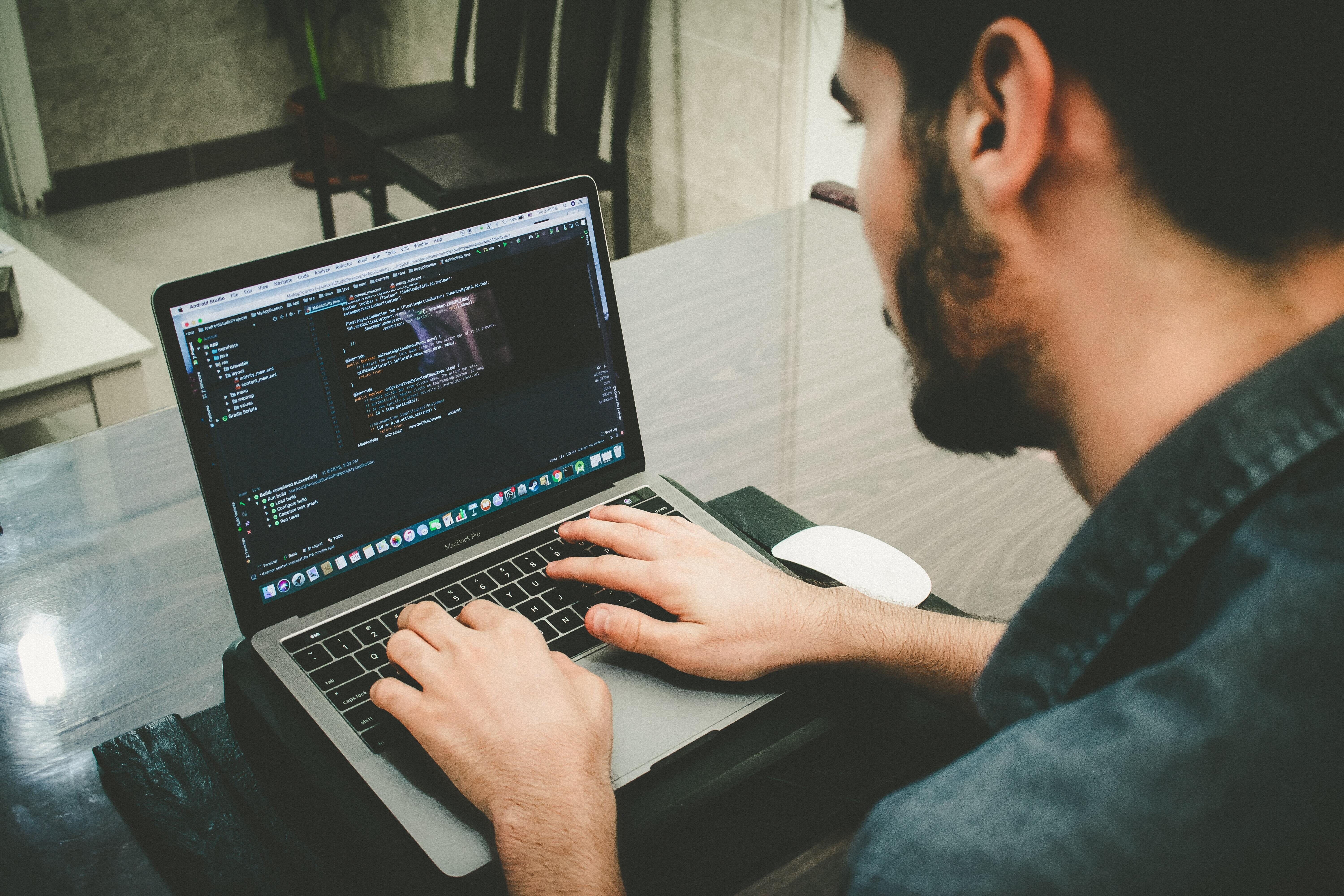 Man Working on a Laptop While Programming Code