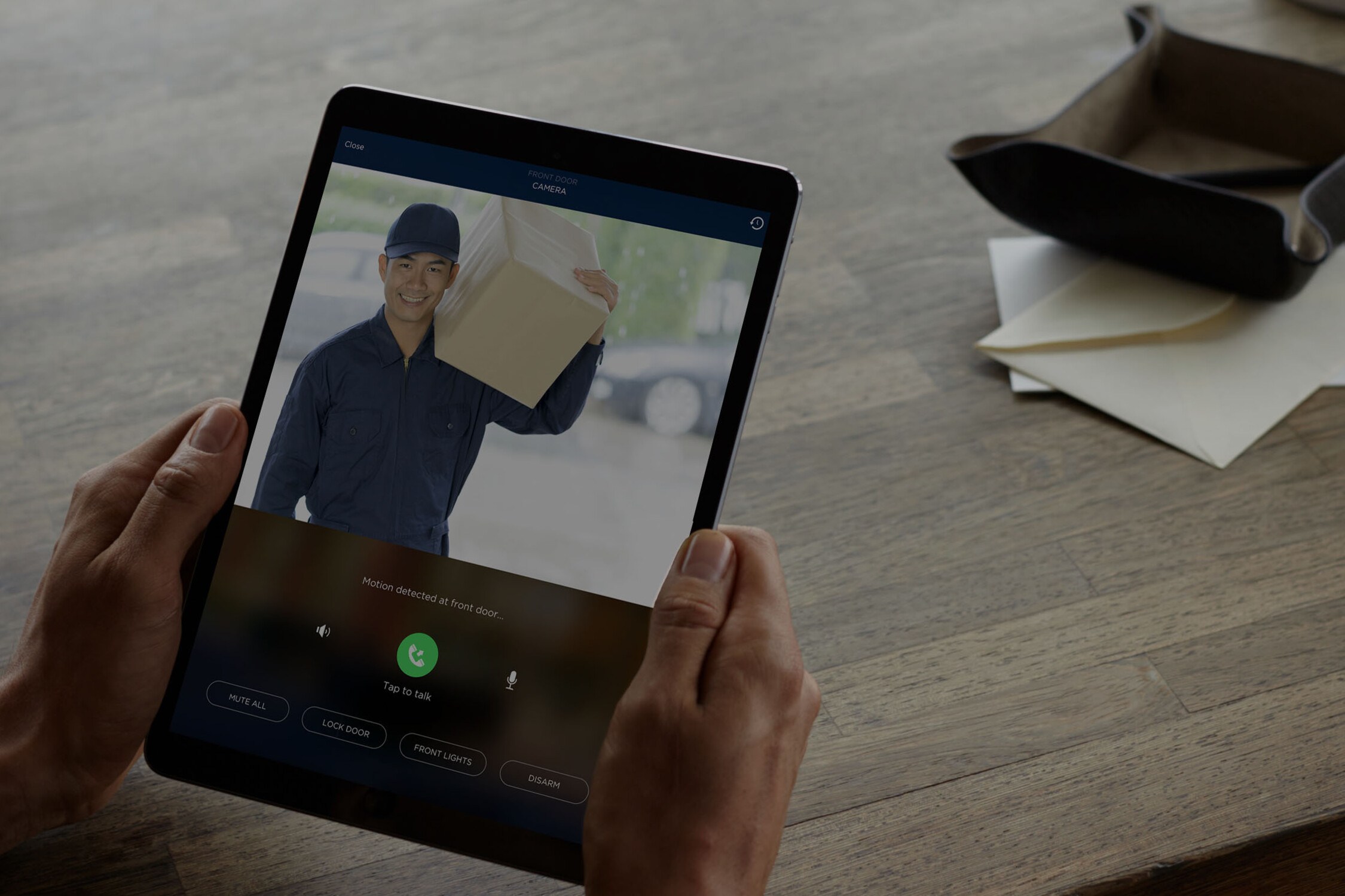 Pair of Hands Holding a Tablet Viewing Delivery Person at Door