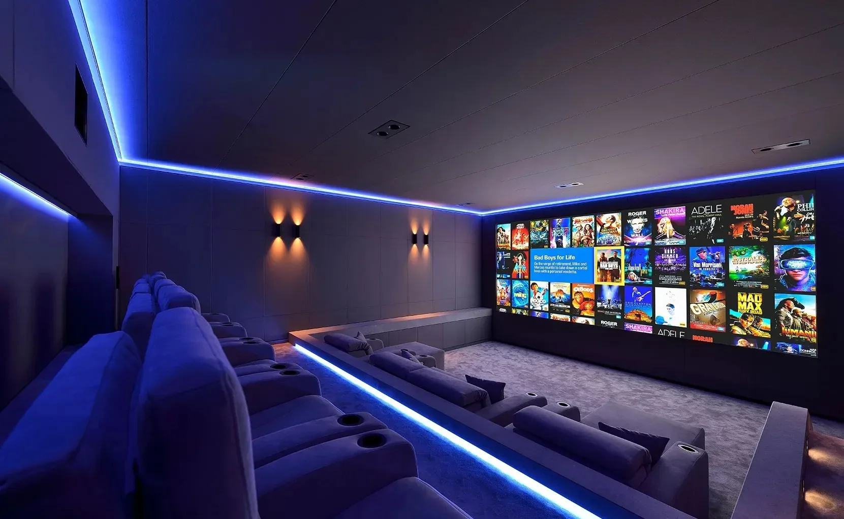 A theater lit in blue with step lighting along tiered seating