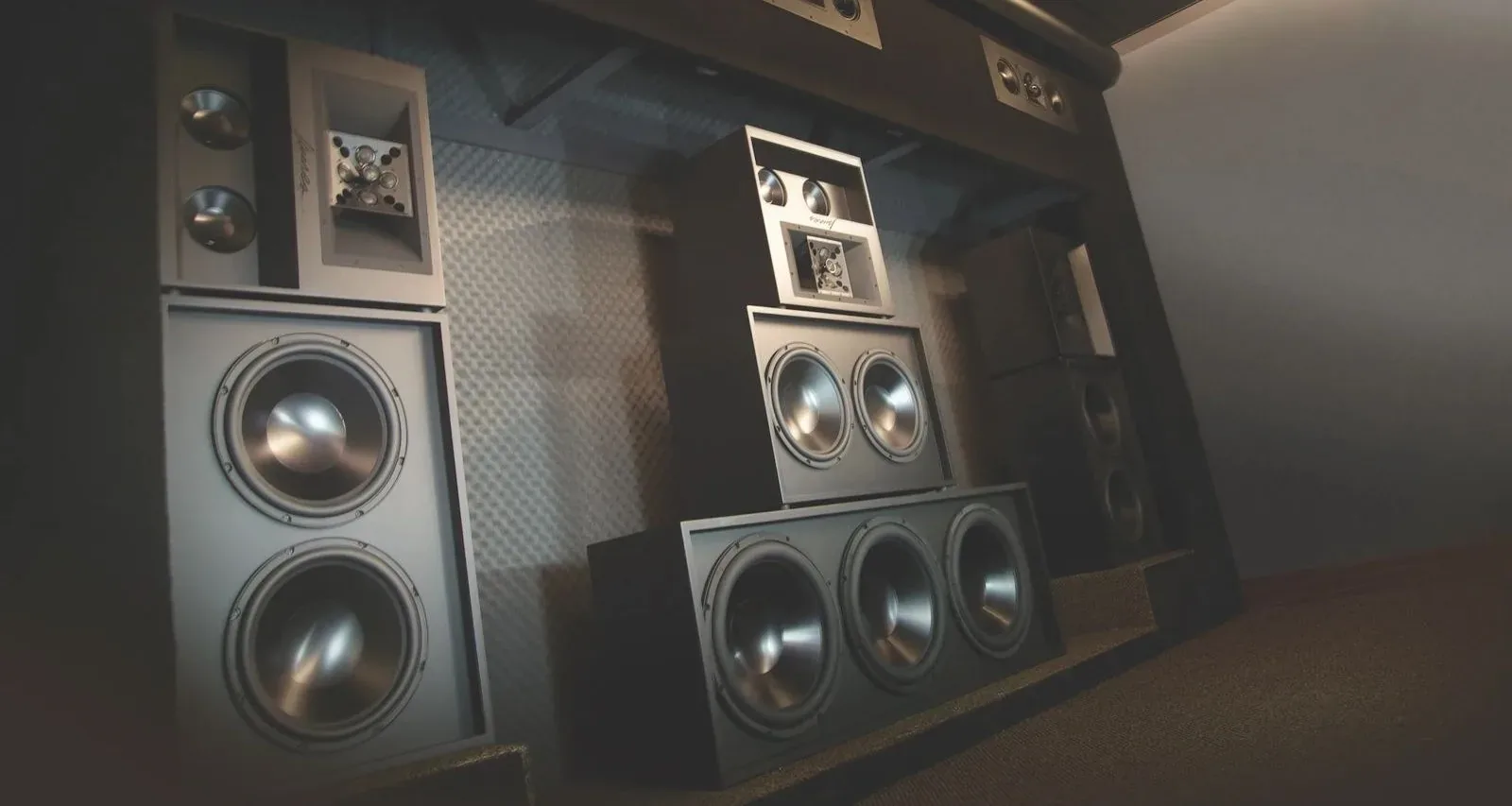 A wall of reference speakers and subwoofers behind an acoustically transparent screen
