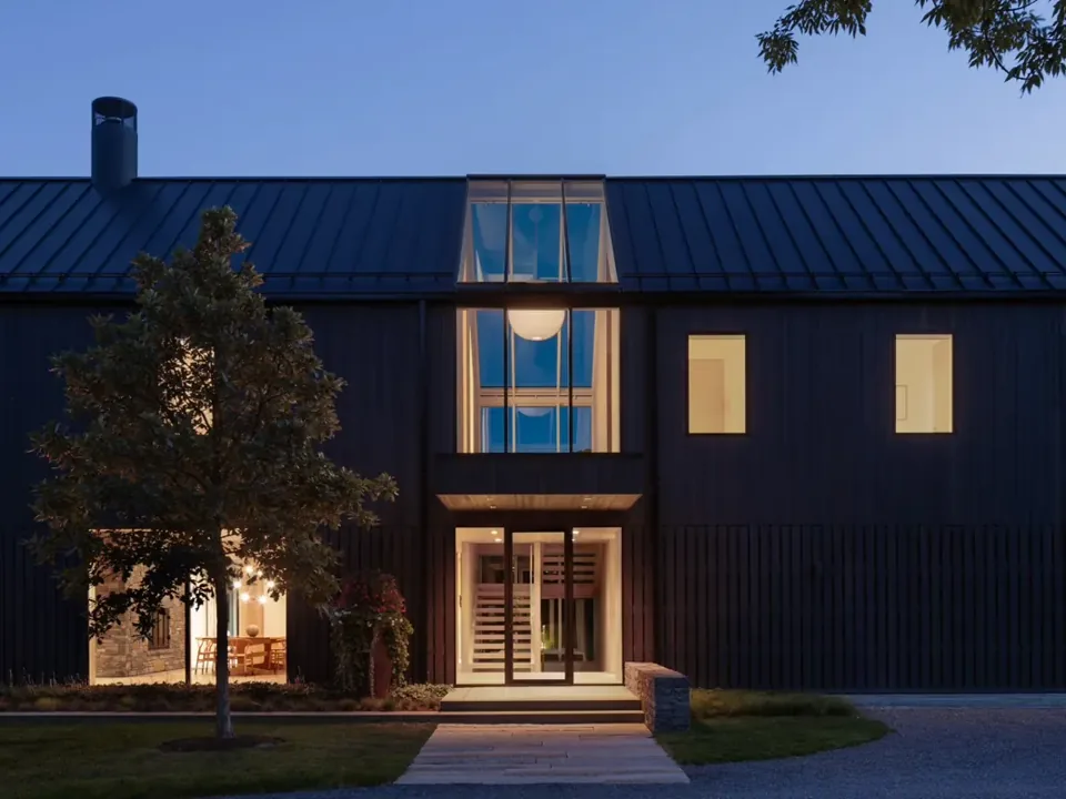 Atrium at dusk, its black-clad walls lit from within