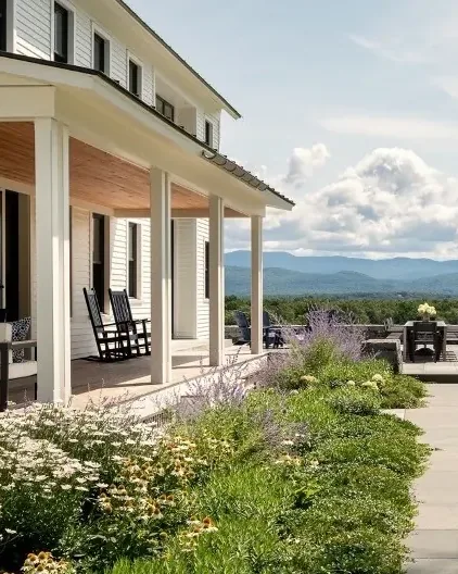 A stone path through flowering gardens to a farmhouse porch in Cornwall